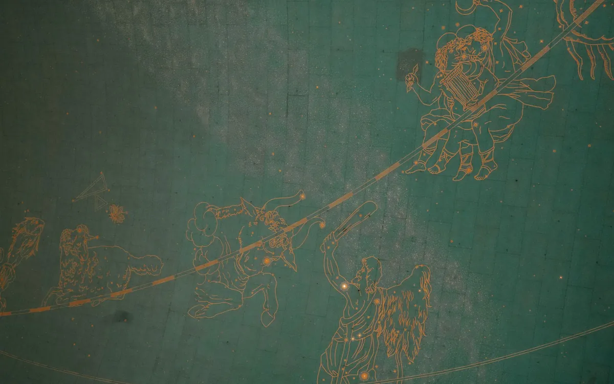 Carved constellation figures on an old chart