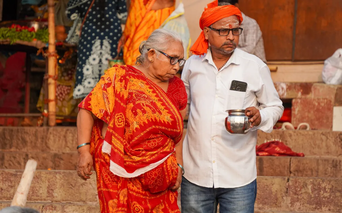 An elderly Indian couple standing on temple steps