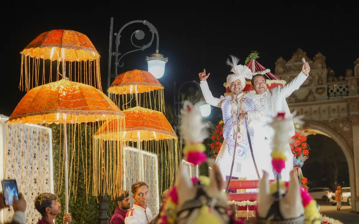 A groom's baraat procession at night with decorated umbrellas