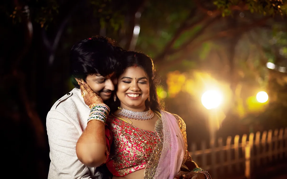 An Indian couple smiling together at an evening engagement function