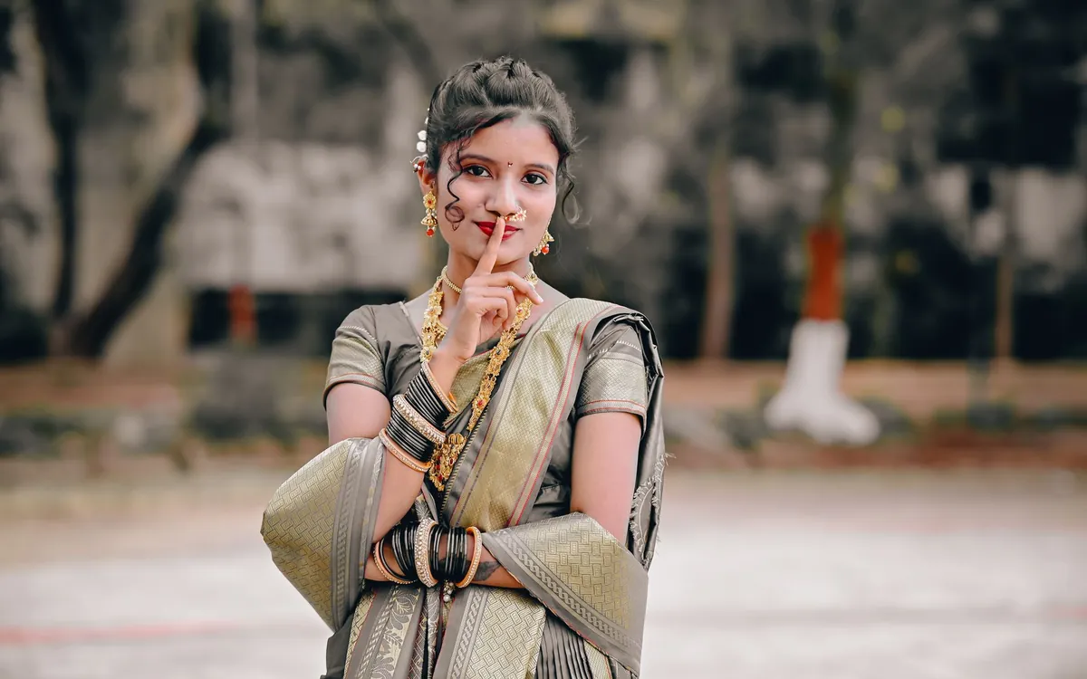 A young Indian woman in a saree smiling at the camera