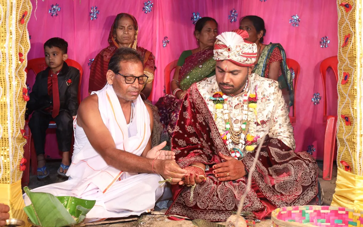A groom seated with his family during a Hindu wedding ritual