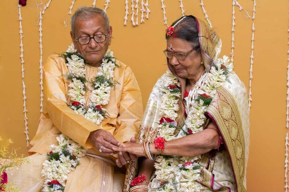 An elderly couple in traditional dress at a family celebration
