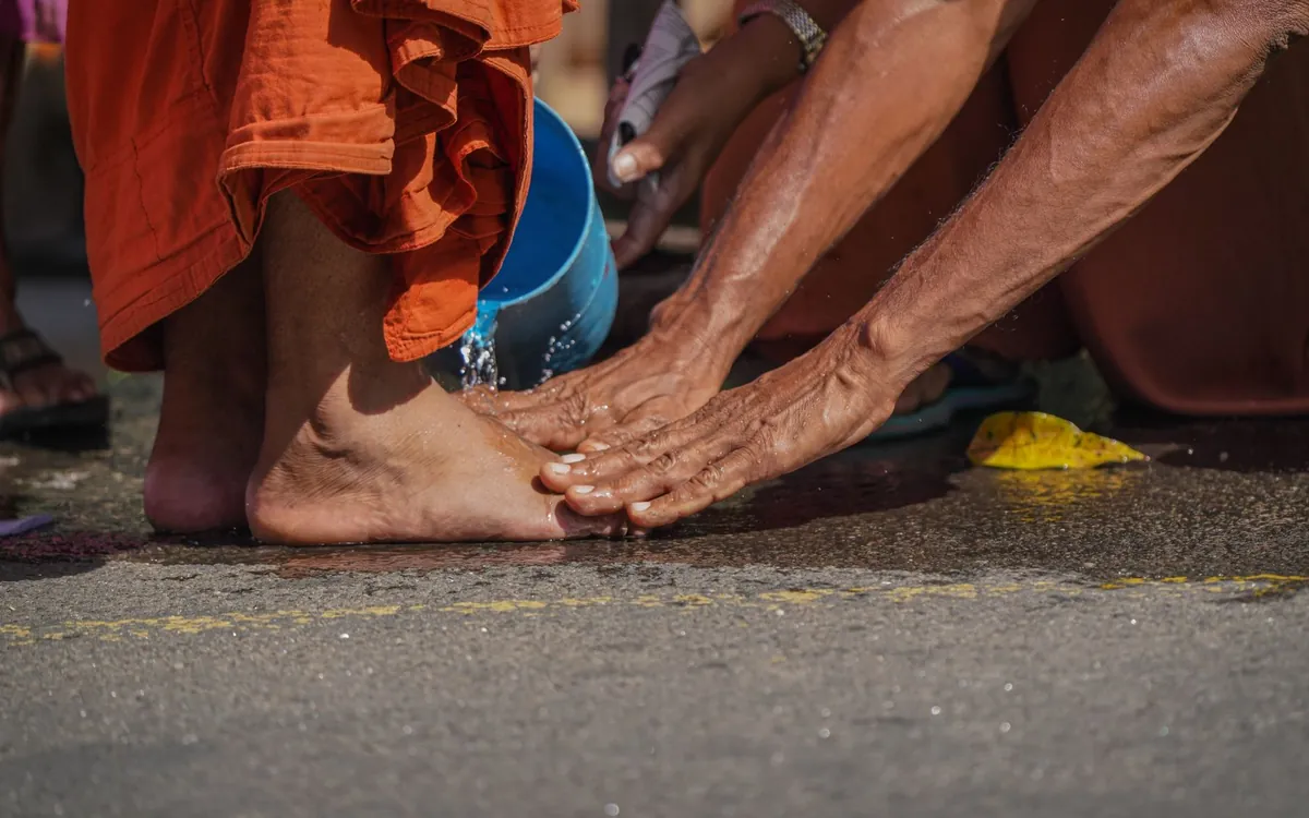 Hands touching an elder's feet in a gesture of respect