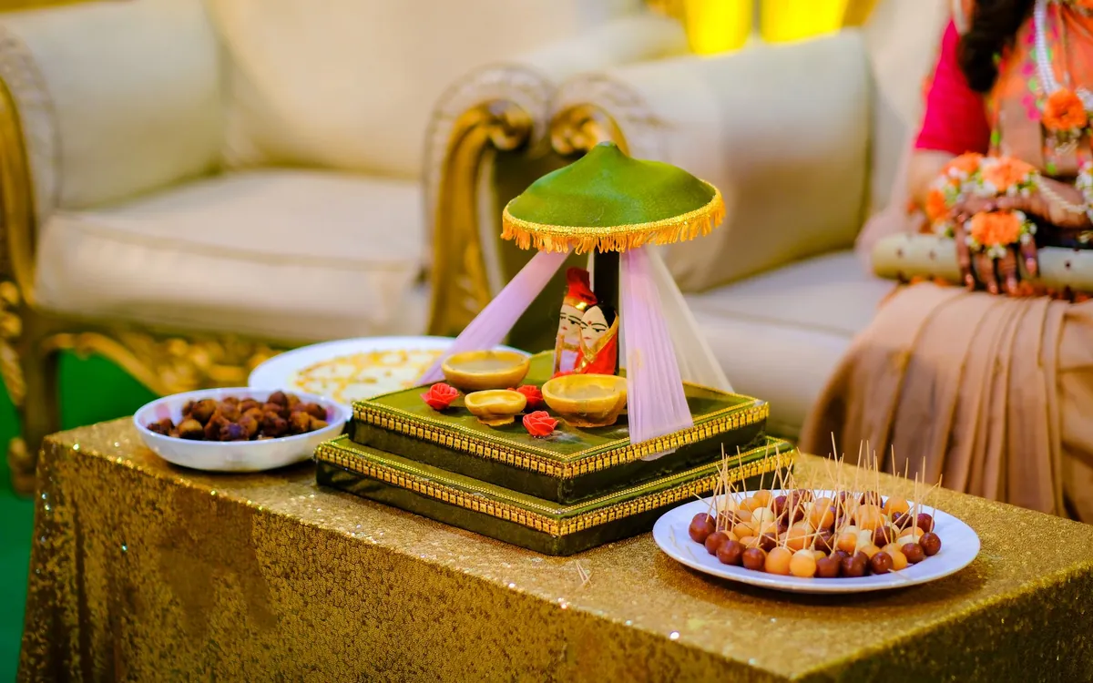 A ceremonial plate with sweets and dry fruits on a decorated table