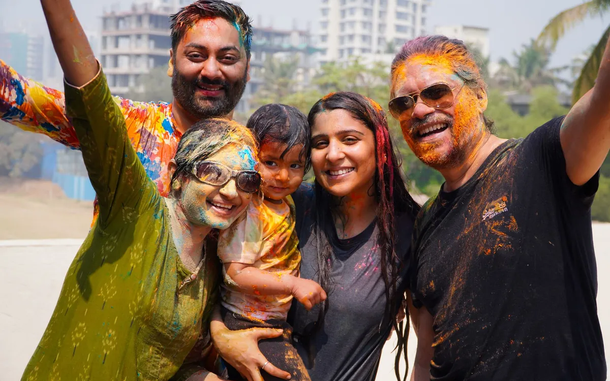 An Indian family celebrating Holi together with coloured faces