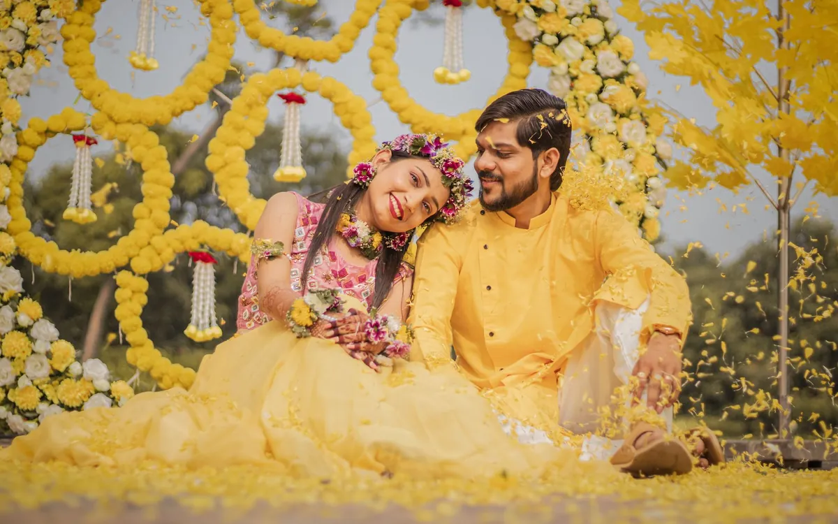 A couple sitting together among yellow marigold decorations