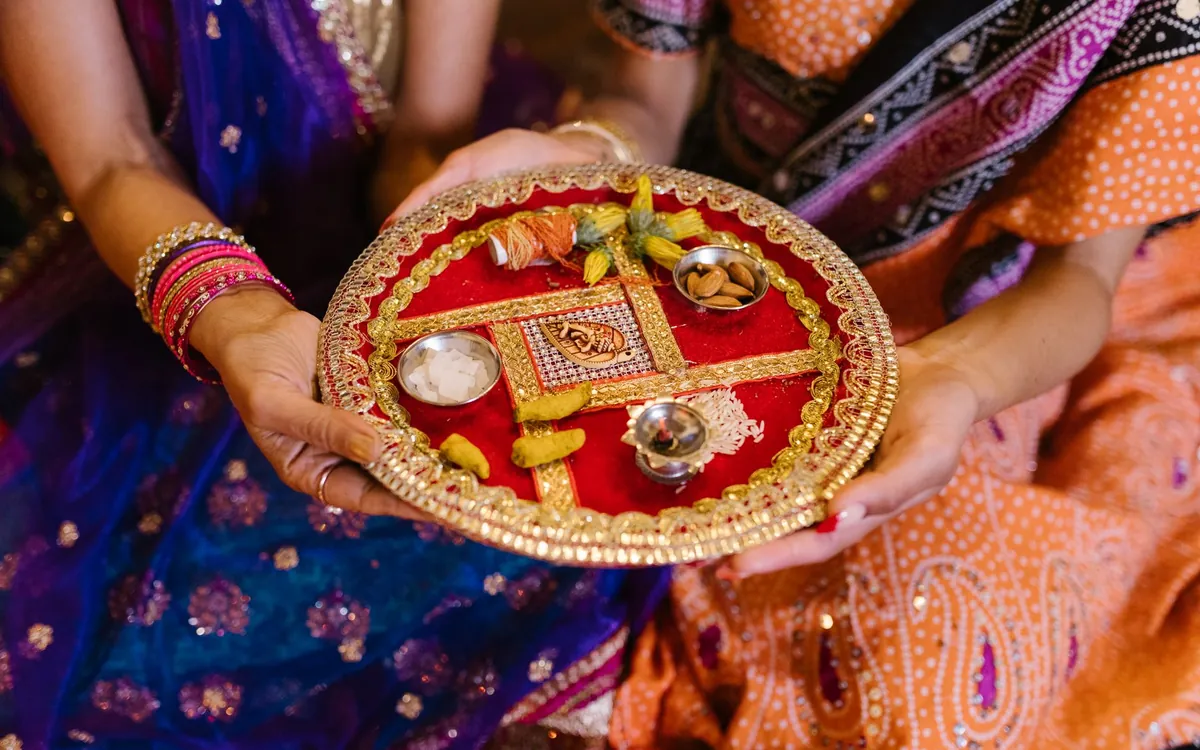 A woman holding a decorated puja thali