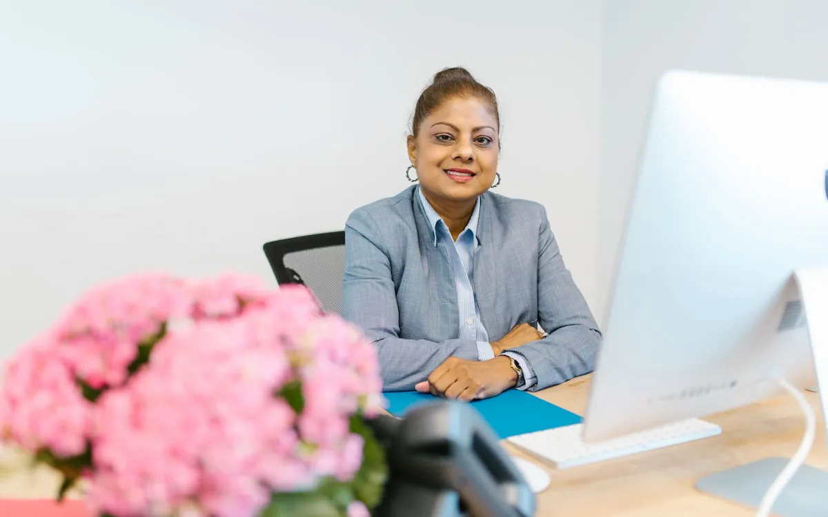 An Indian woman professional smiling at her office desk