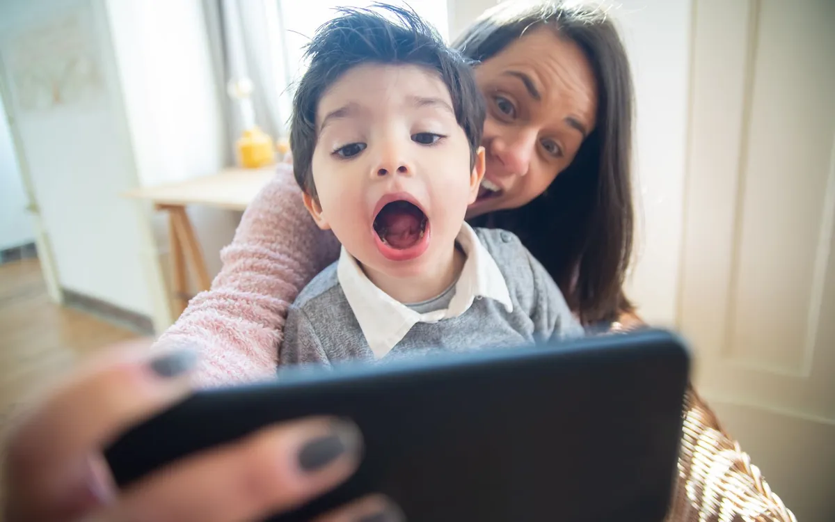 An Indian mother and young son looking at a phone screen