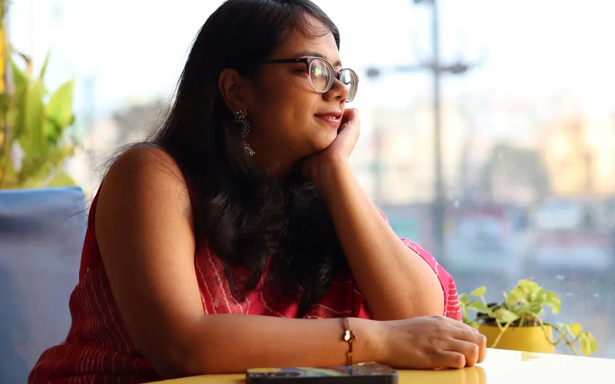 A young Indian woman sitting by a window, deep in thought