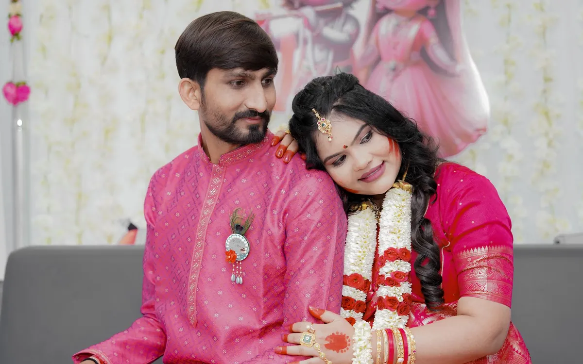 An Indian couple smiling together, wearing wedding garlands