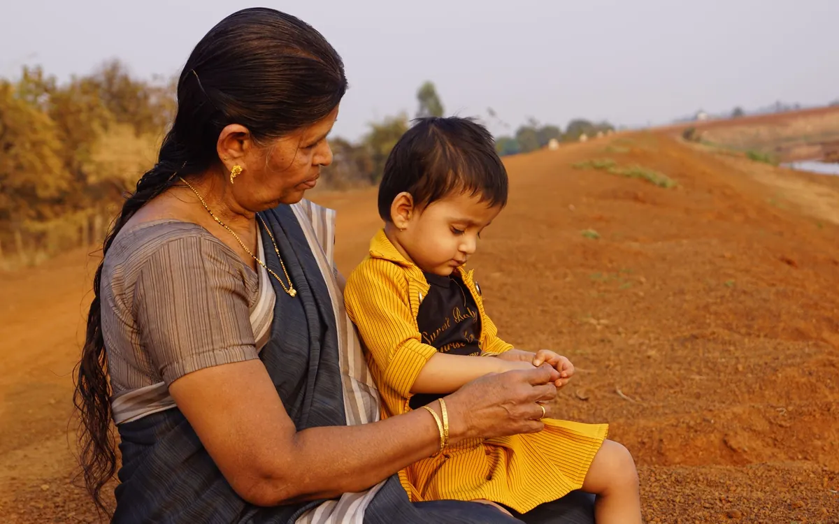 An Indian grandmother sitting with a young child outdoors