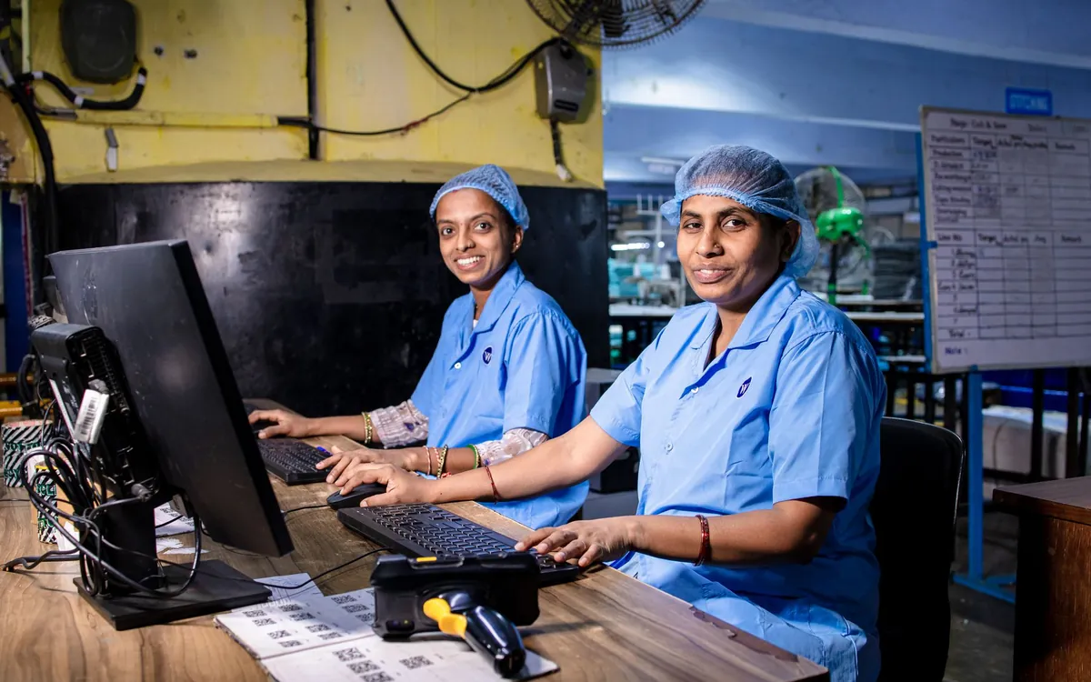 Two women in scrubs working at computers in an office