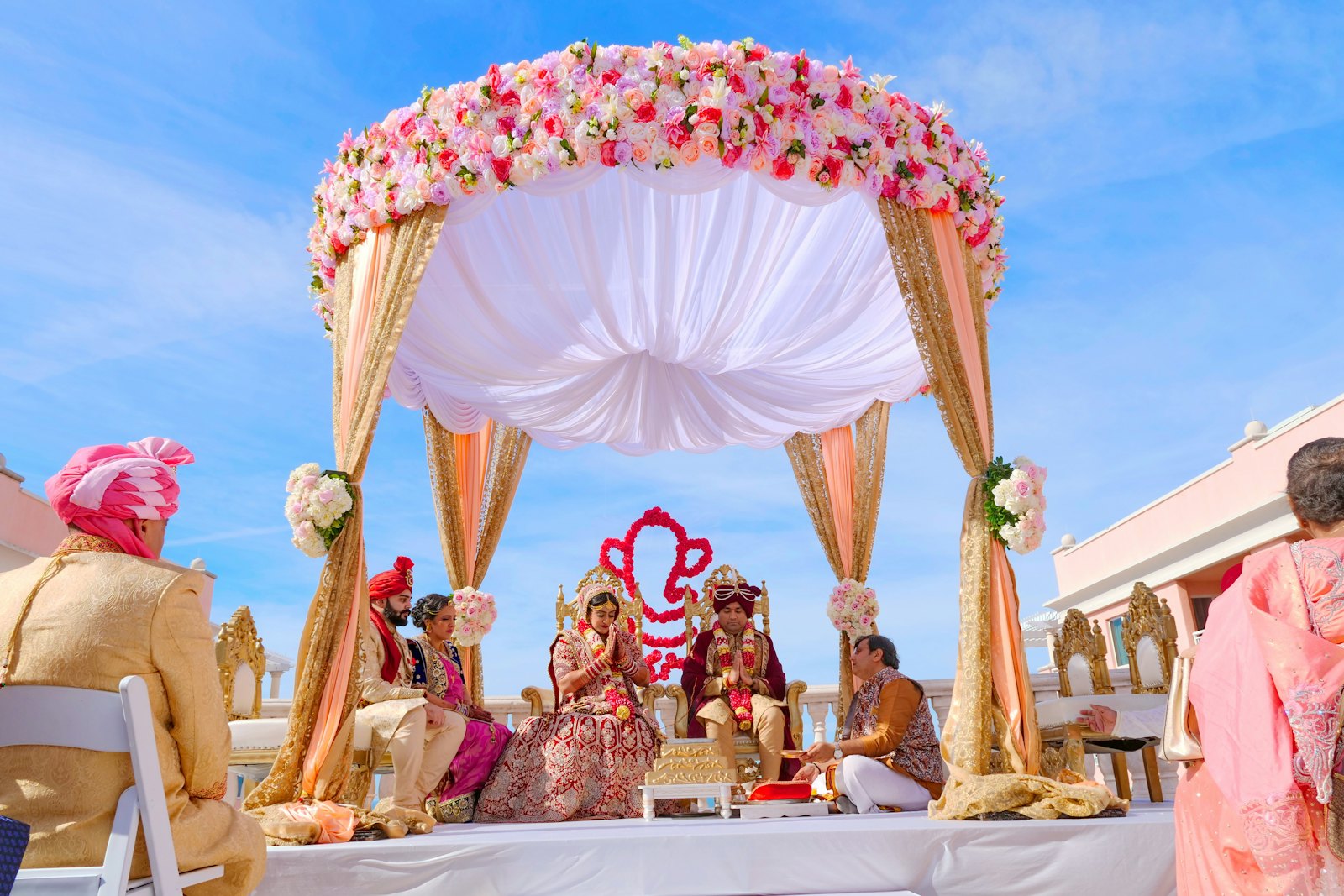 A traditional Indian wedding ceremony under a floral mandap